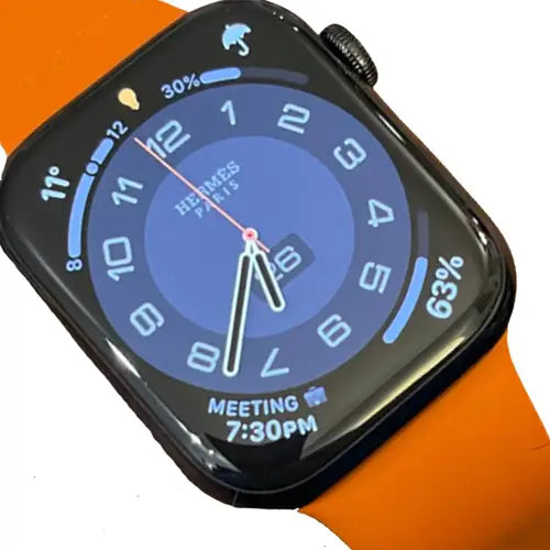 a7 hermes orange band smart watch with a black case, displaying a blue watch face, indicating time as 7:30 PM with a meeting reminder, and battery level at 63%.