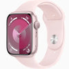 This image features the Apple Watch Series 9 in a 45mm size, showcased with a sleek pink band and a matching pink case. The watch face displays a vibrant, detailed interface with various app icons and a prominent digital crown on the side.