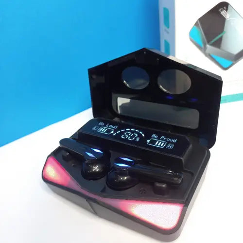 A pair of M28 TWS Wireless Earbuds in black color, with a charging case that has a red light beneath the earbuds. The earbuds are displayed in an open case, and the charging case is placed on a blue surface.