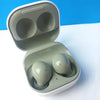 Samsung Galaxy Buds 2 earphones in olive color, placed inside their charging case.