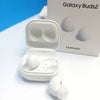 Samsung Galaxy Buds 2 earphones in white color, placed inside their charging case.