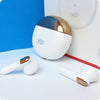 A pair of white and gold XO X13 Magic Ring TWS Bluetooth earbuds on a surface with a charging case in the background.