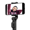 Smartphone mounted on a Xiaomi Selfie Stick Tripod with a person's face displayed on the screen against a white background